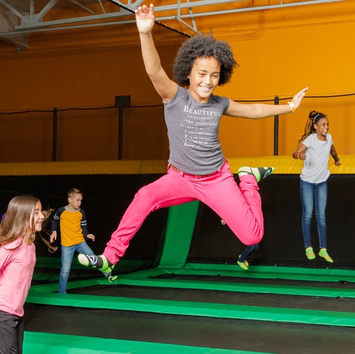 niña saltando y sonriendo a rockin jump